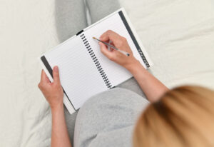 Pregnant woman taking notes in a notebook