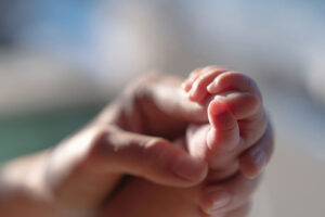 Newborn baby is holding the mother's hand